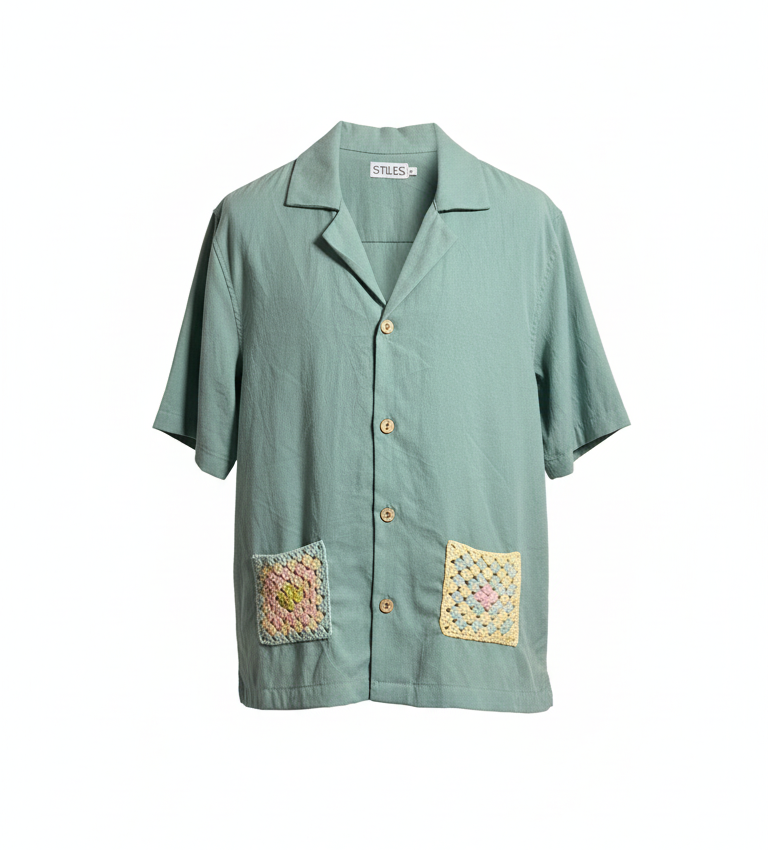 Green shirt with embroidered patches on a white background